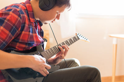 Man playing guitar at home