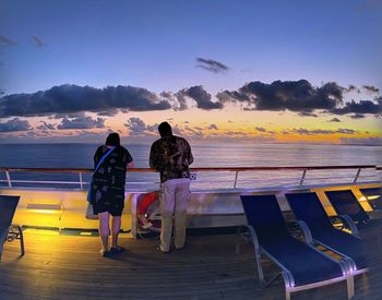 Rear view of people looking at sea against sky