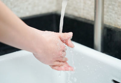 Cropped image of person hand in water