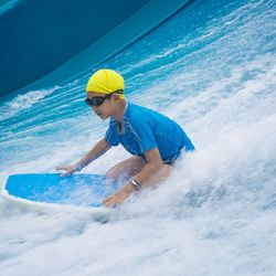 Boy surfing in sea