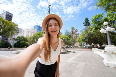 Beautiful traveler girl takes self portrait in porto alegre, brazil