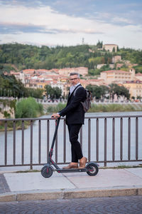 Man riding bicycle on railing in city