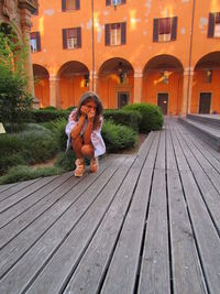 Full length of woman sitting outdoors