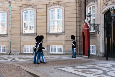 People walking on street against building in city