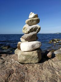 Stack of pebbles on beach against clear sky