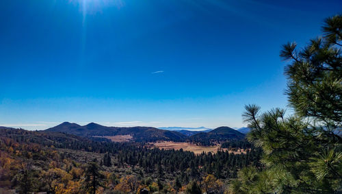 Scenic view of mountains against blue sky