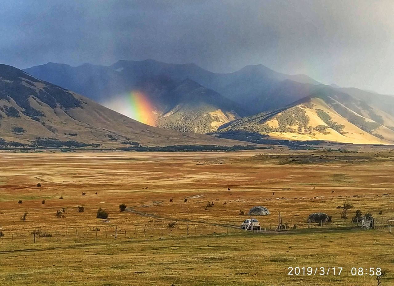 SCENIC VIEW OF FIELD AGAINST MOUNTAINS