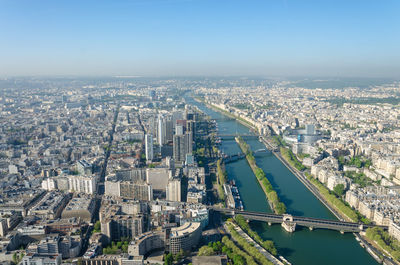 Aerial view of river amidst cityscape against clear sky