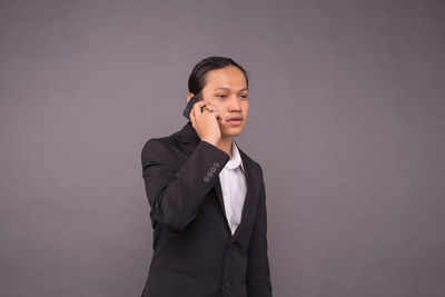 Young man looking away against white background