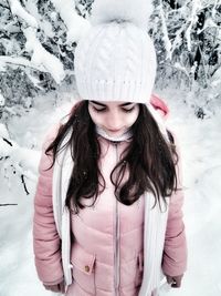 Young woman in warm clothing standing on snow