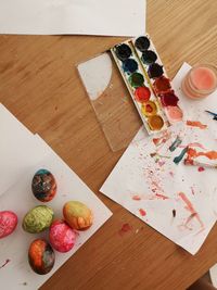 High angle view of various watercolors and easter eggs on table