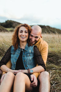 Happy young woman sitting on land