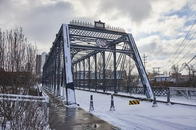 Bridge over river against cloudy sky