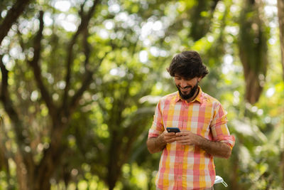 Young man at park on a beautiful sunny day with mobile phone.  working  leisure. green and nature 