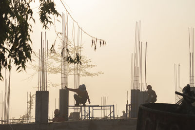 Silhouette people against clear sky in city