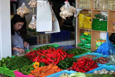 Woman picking vegetable while standing at market
