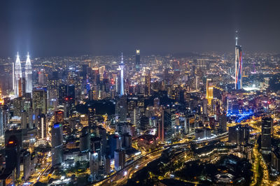 Illuminated cityscape against sky at night