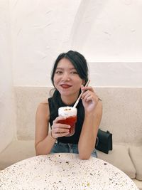 Portrait of a young woman drinking water