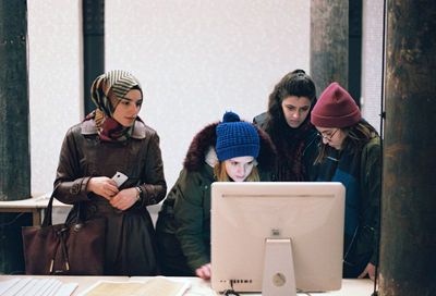 Friends standing on snow covered phone in winter