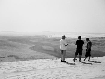 Rear view of man standing on snow covered landscape