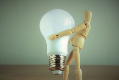 Close-up of light bulb against wall