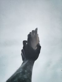 Low angle view of hands against sky
