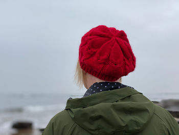 Rear view of woman wearing a red hat looking at sea against sky