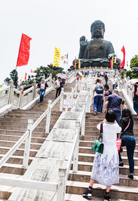 Rear view of people at temple against sky