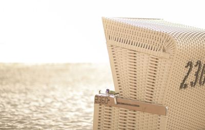 Close-up of hooded beach chair against clear sky