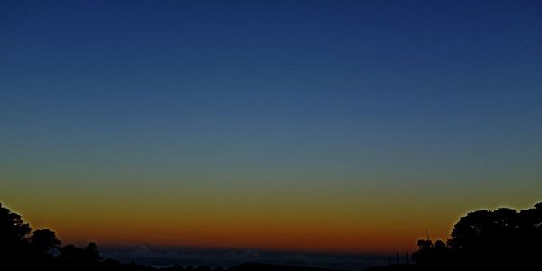 Scenic view of silhouette landscape against clear sky at sunset