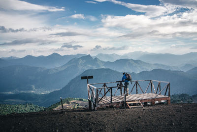 Man standing at observation point against mountains