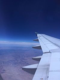 Airplane flying over clouds against blue sky