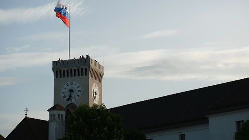 Low angle view of clock tower amidst buildings against sky