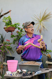 Full length of man holding potted plant