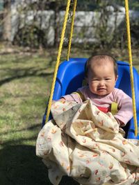 Portrait of cute girl sitting on slide at playground