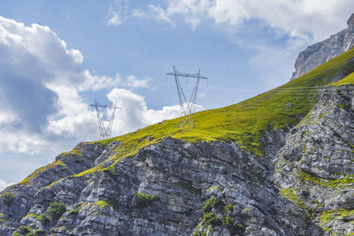Low angle view of cross on rock against sky