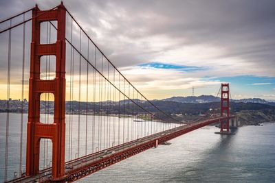 View of suspension bridge against cloudy sky