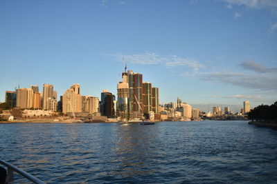 Sea by buildings against sky in city