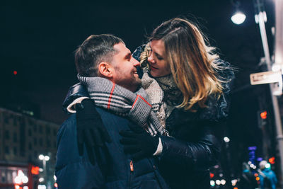 Young couple kissing in winter at night