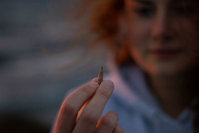 Tiny shell held in hand on a beach at sunset