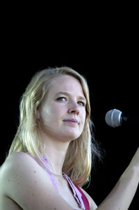 Portrait of a smiling young woman over black background