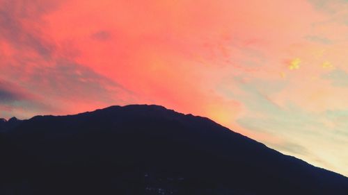 Scenic view of silhouette mountains against dramatic sky