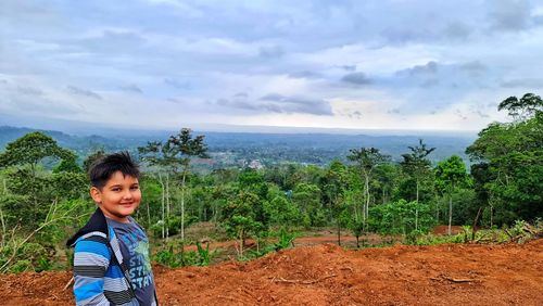 Portrait of boy standing on mountain against sky