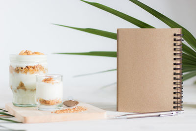 High angle view of dessert in glass by book and pen on table