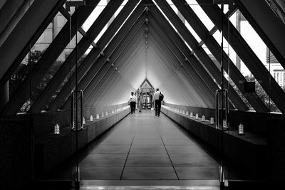 Rear view of people walking on footbridge