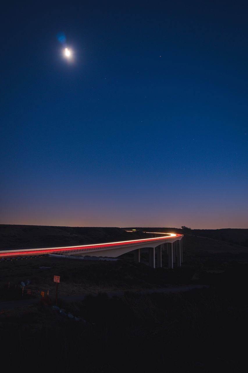 LIGHT TRAILS ON ROAD AT NIGHT
