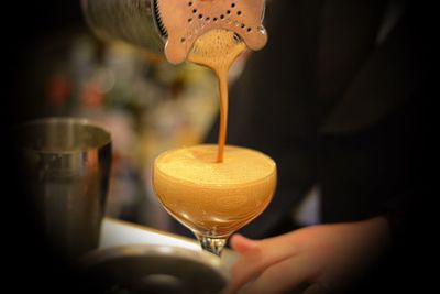 Midsection of man putting coffee in glass