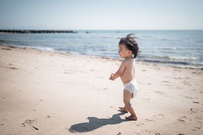 Full length of boy running on beach