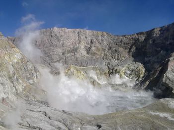 Scenic view of waterfall against sky