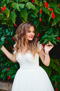 Portrait of young woman against plants